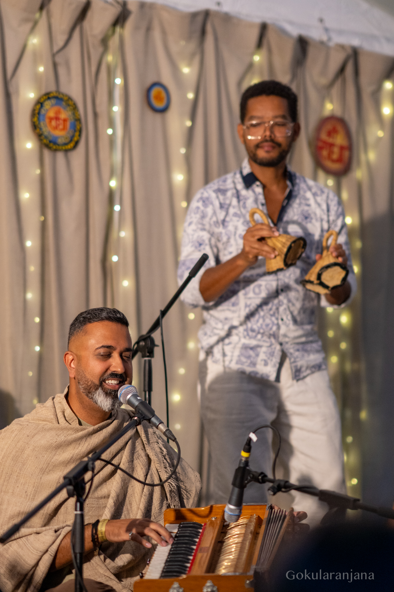 Musiker beim Kirtan mit Harmonium und Kartals