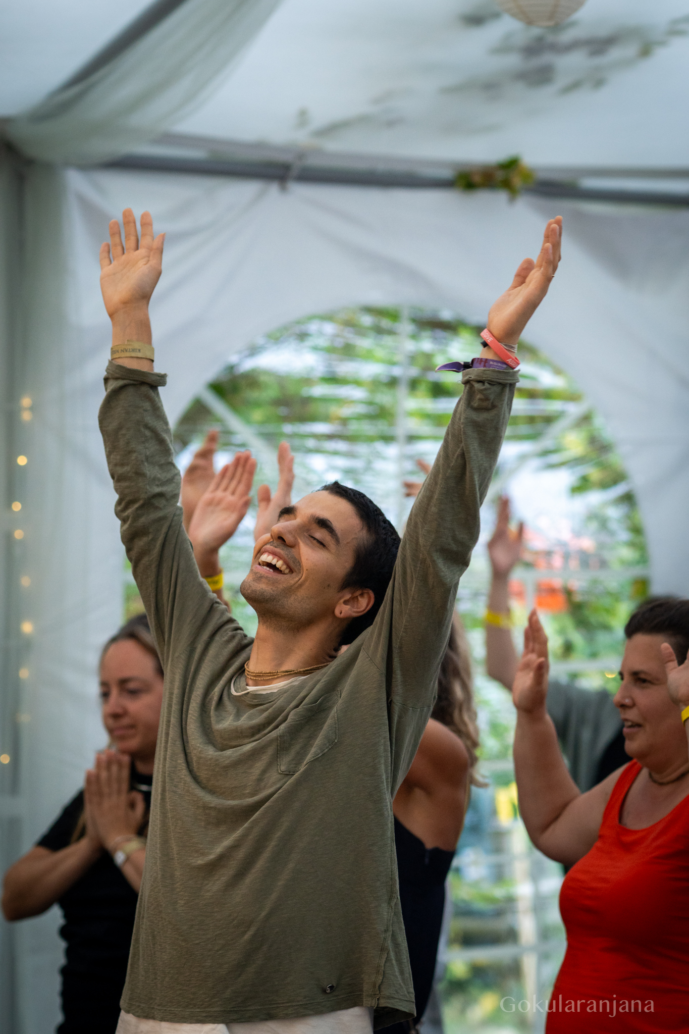 Ein Teilnehmer singt beim Kirtan voller Freude mit erhobenen Armen